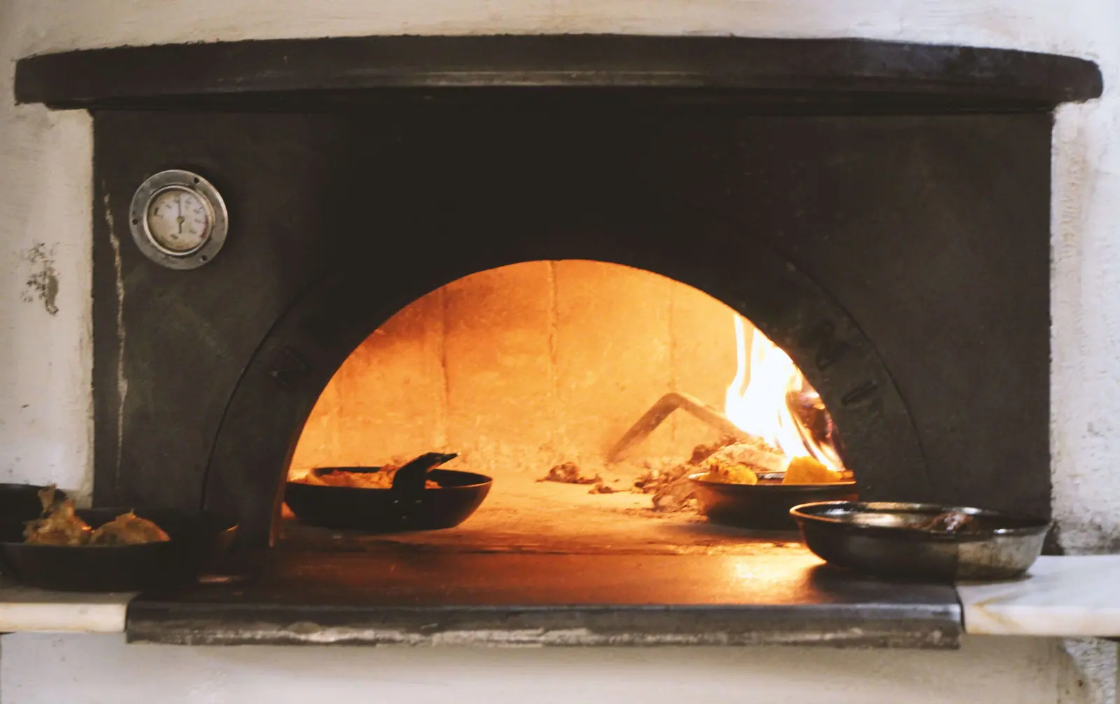 The wood-fired oven at Pharaoh, burning behind an open arch