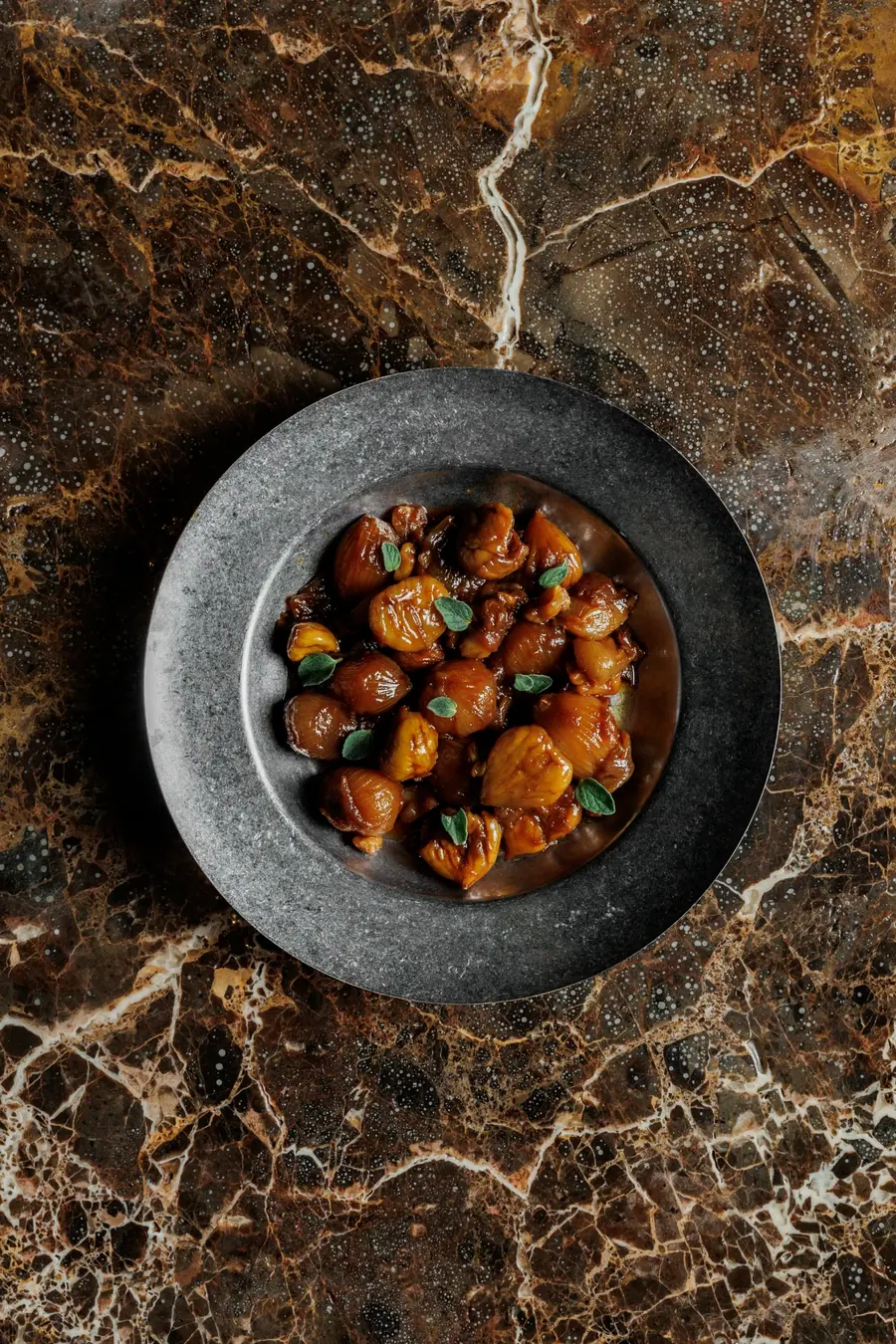 Iron pan of stewed dish on a marble counter